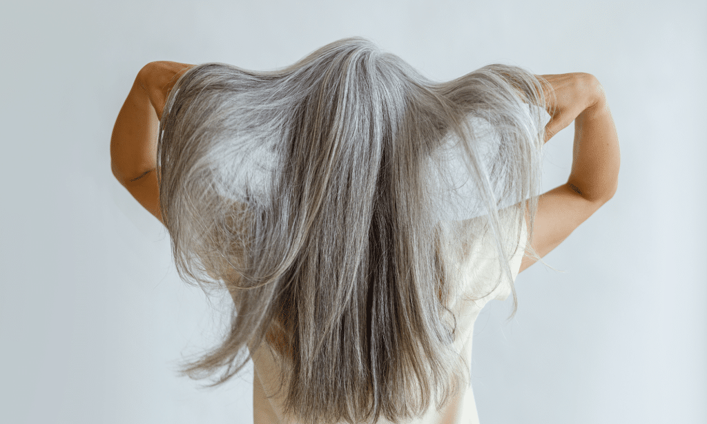 confidant older woman showing off and being proud of her gray hair