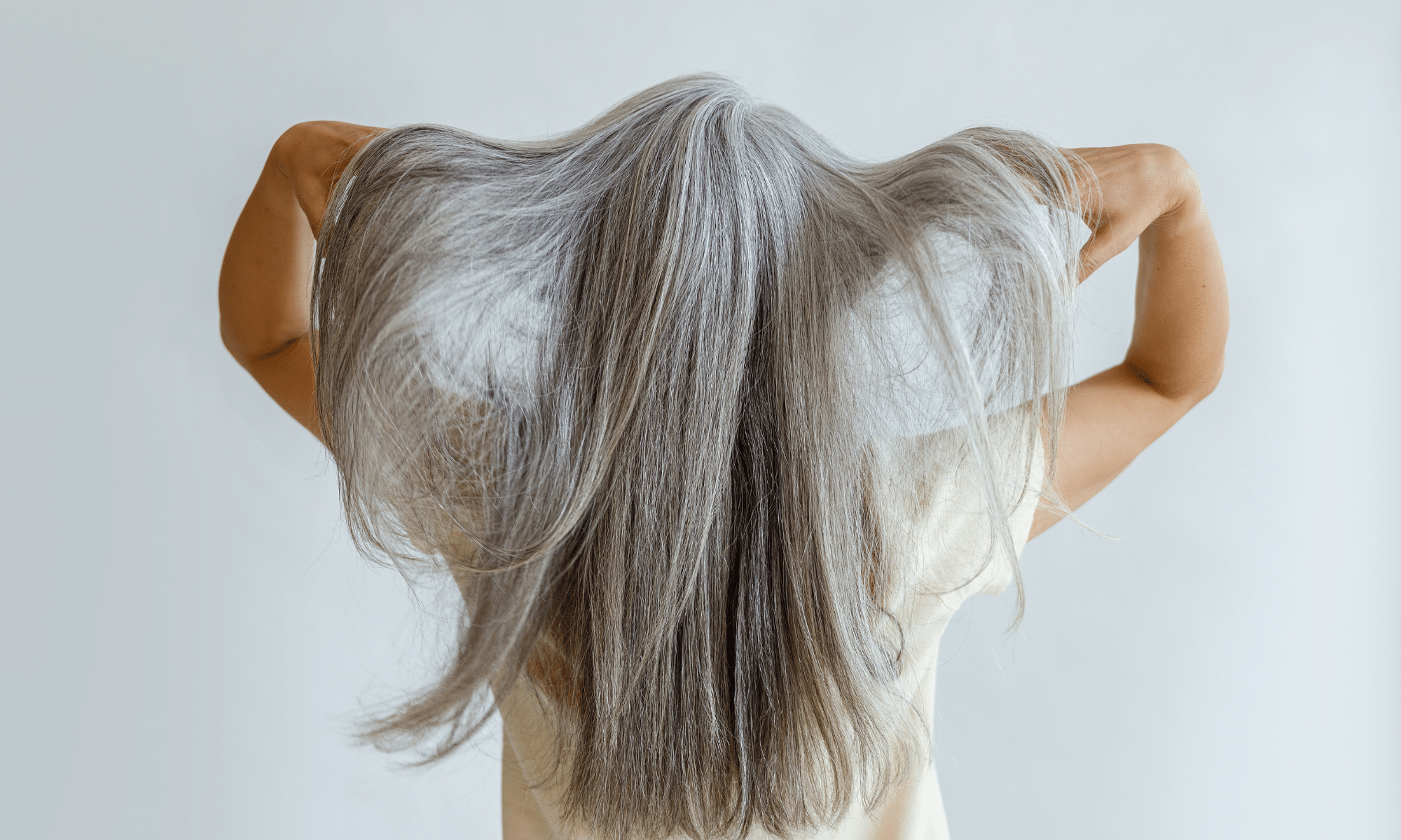 confidant older woman showing off and being proud of her gray hair