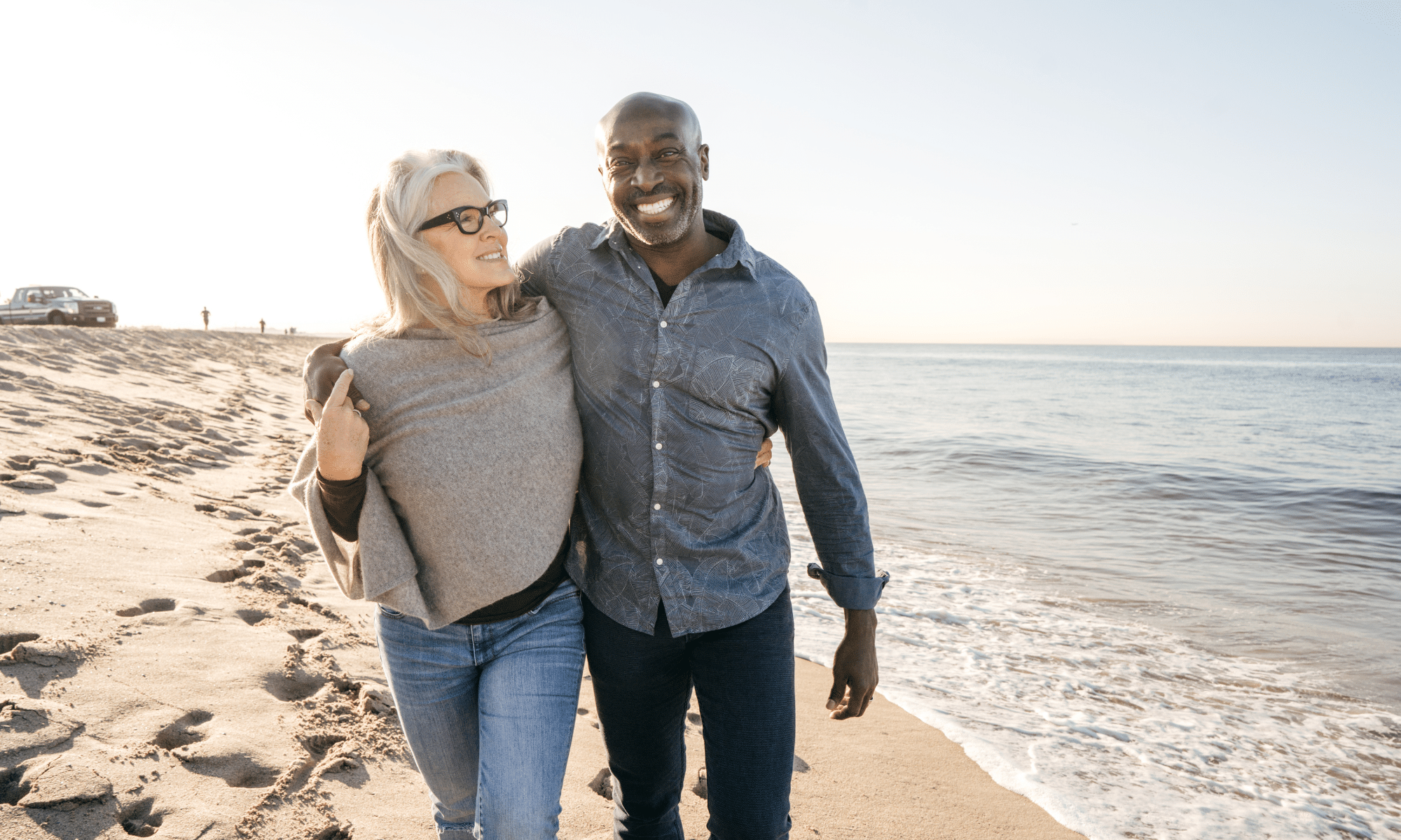 an older couple walking on the beach to boost their mental health